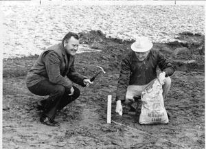 Two Men Smiling While Crouched at the Dirt